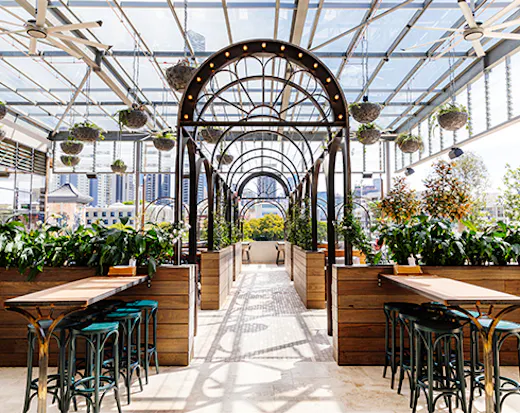 a metal arbour between tables on a rooftop 