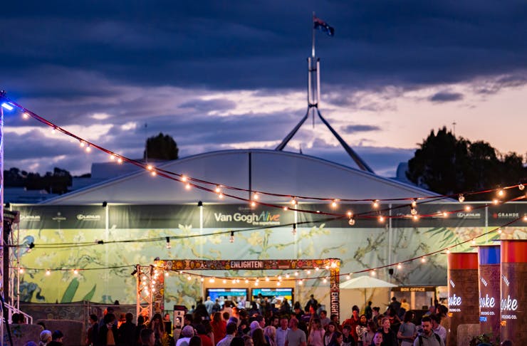 Crowds gather outside a large marquee at dusk for Van Gogh Alive