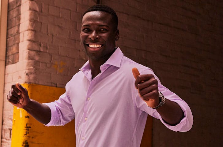 A model wearing a Van Heusen dress shirt in pink