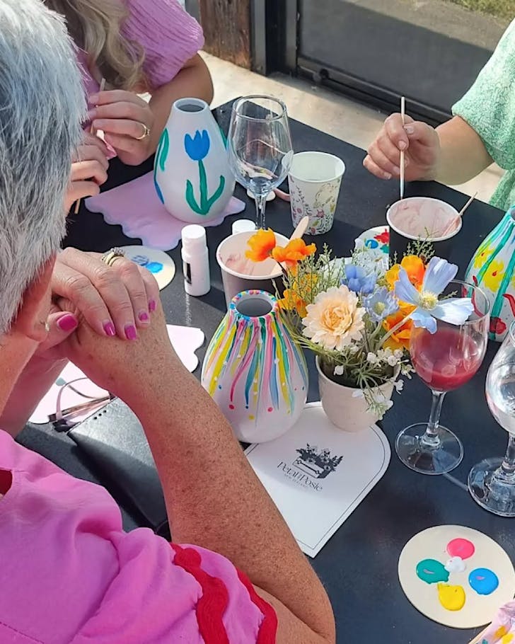 A woman in pink enjoys a Vase & Paint session.