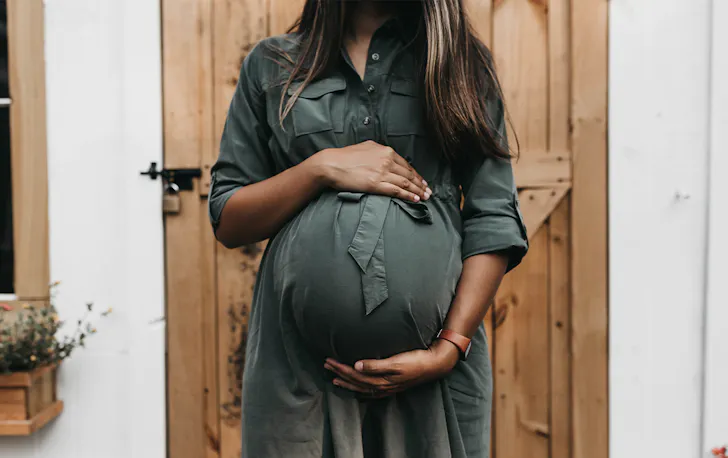 a pregnant woman holding her stomach