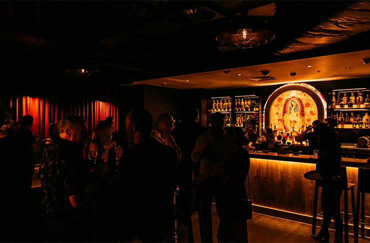 A crowd of people drinking cocktails in the dark interior of Broadbeach's new hidden speakeasy.