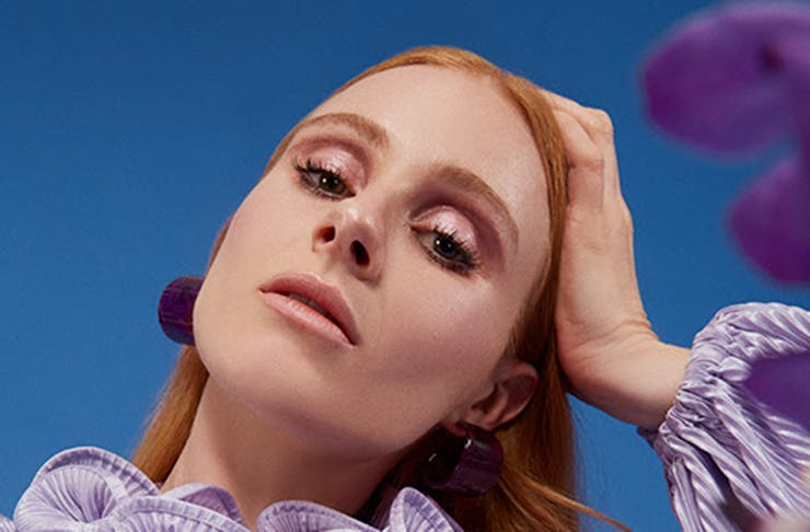 Singer-songwriter Vera Blue in a blue dress. The blue sky can be seen in the background.