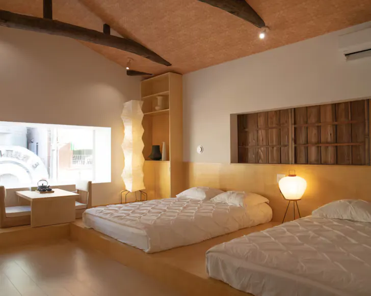 A spacious bedroom with warm, low lighting at a Villa Airbnb in Osaka.