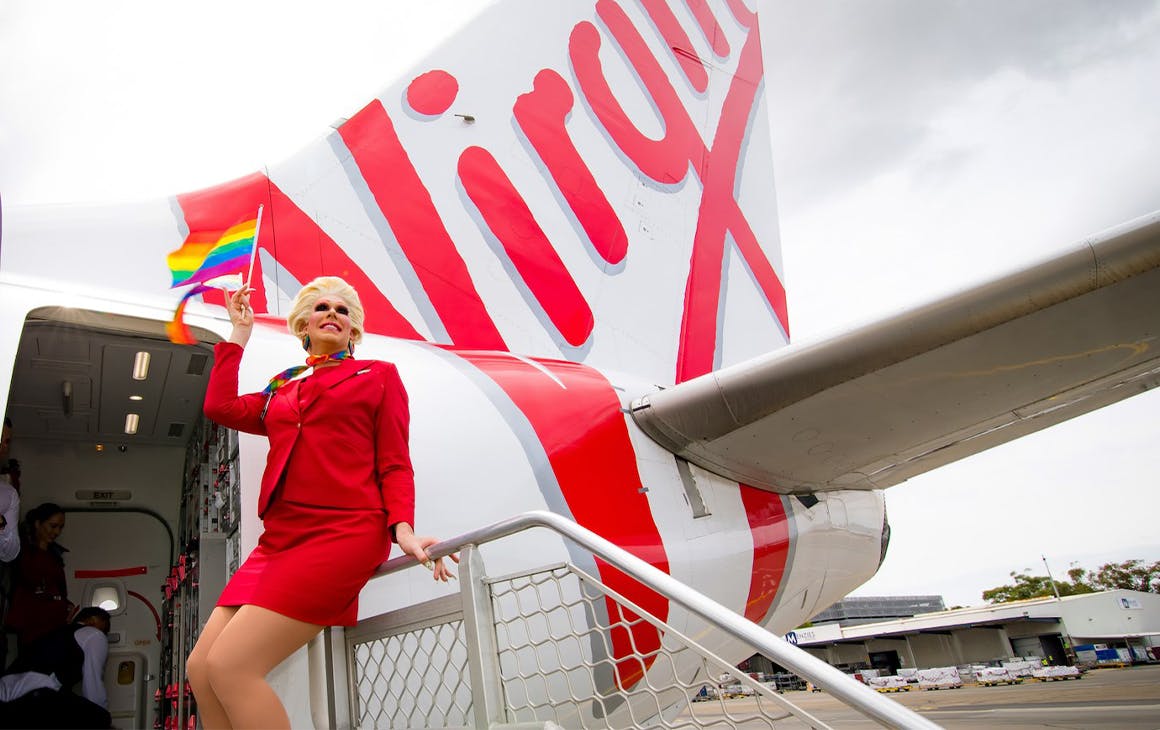 a drag queen in front of a virgin flight
