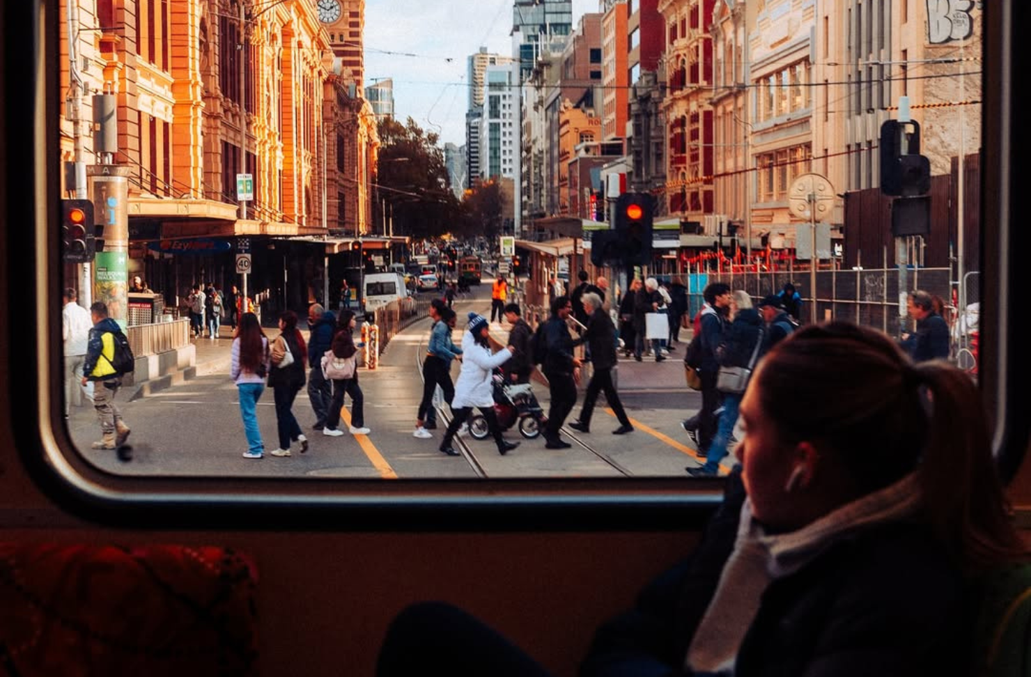 a woman gazes out the window of a tram at Melbourne cbd