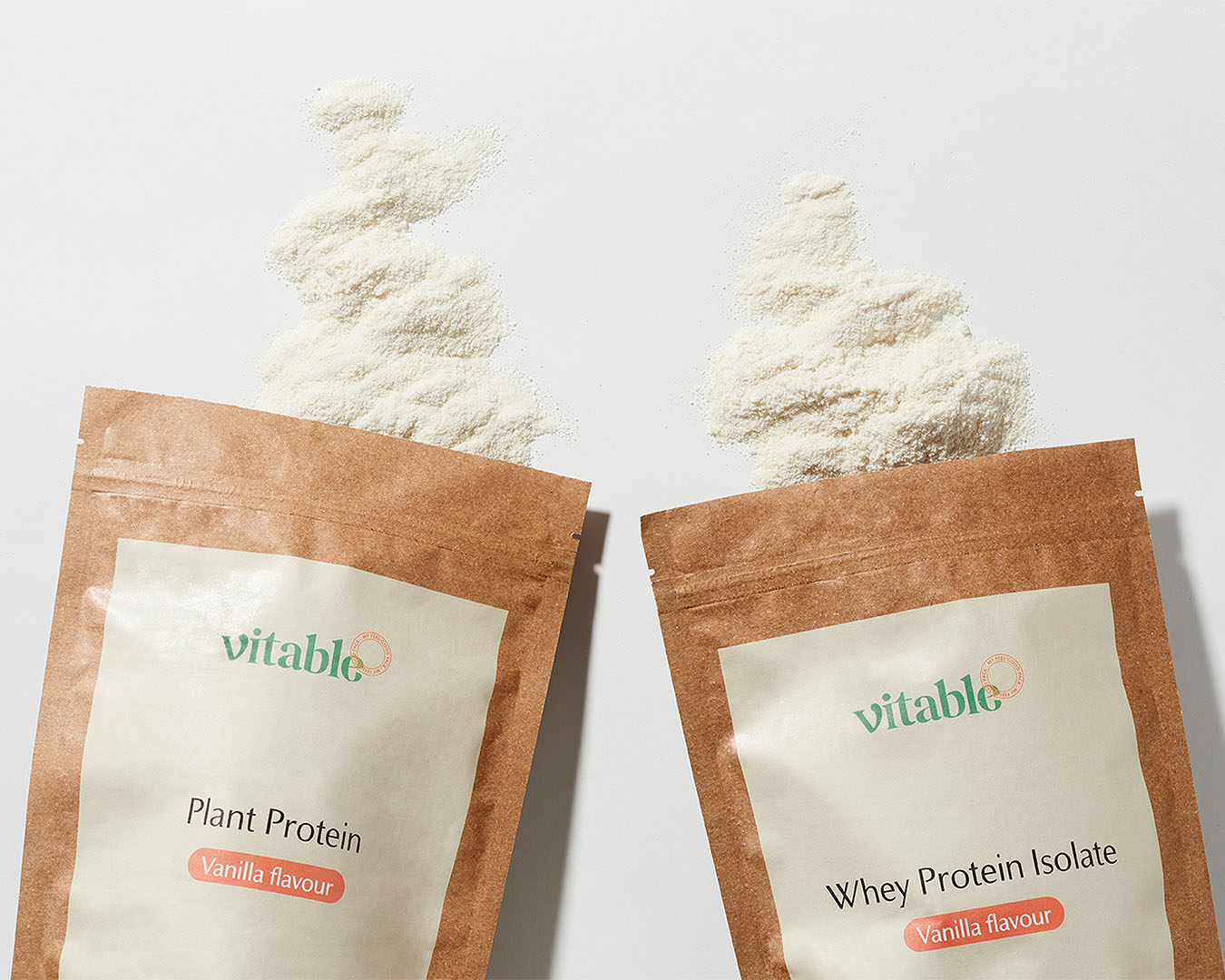 Two Vitable protein powders spilling powder out of the top.