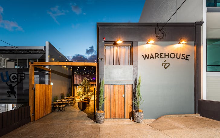 front faced of Warehouse 25, with a laneway lit by fairy lights on one side