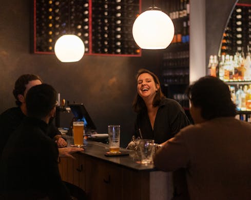 alli laughing behind bar at we three bar marrickville