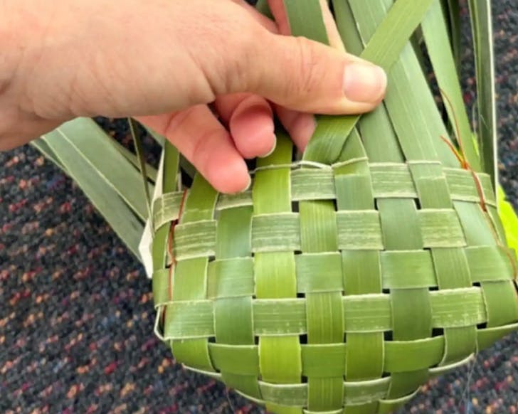 A vibrant green, freshly-woven flax basket.