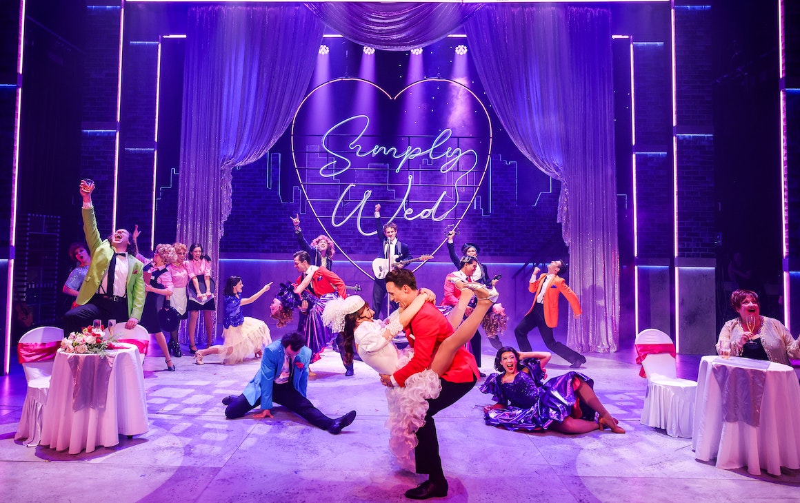 performers dressed in bright 80s-inspired costumes on stage