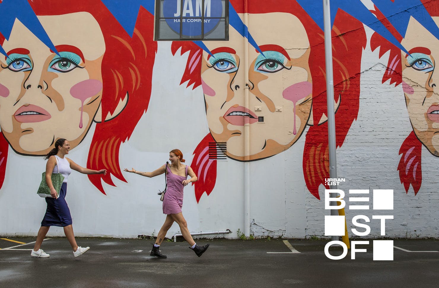 Two people walk by the Bowie mural on Ghuznee Street, Wellington.