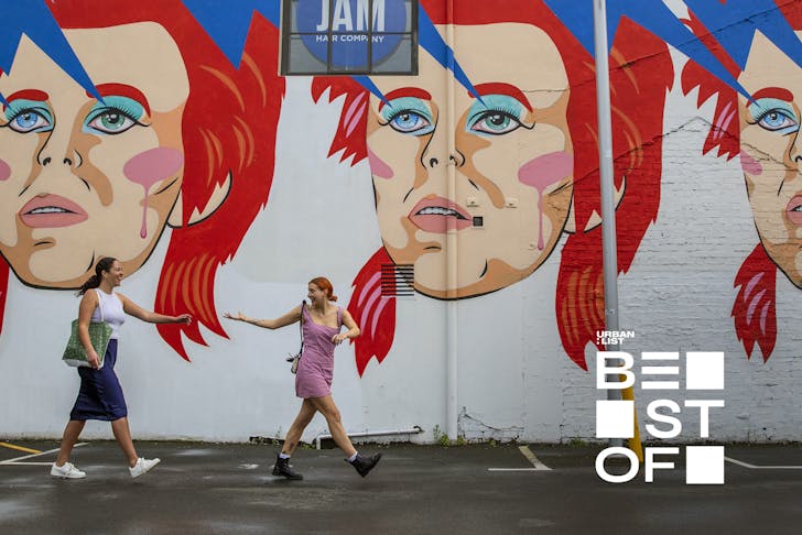 Two people walk by the Bowie mural on Ghuznee Street, Wellington.