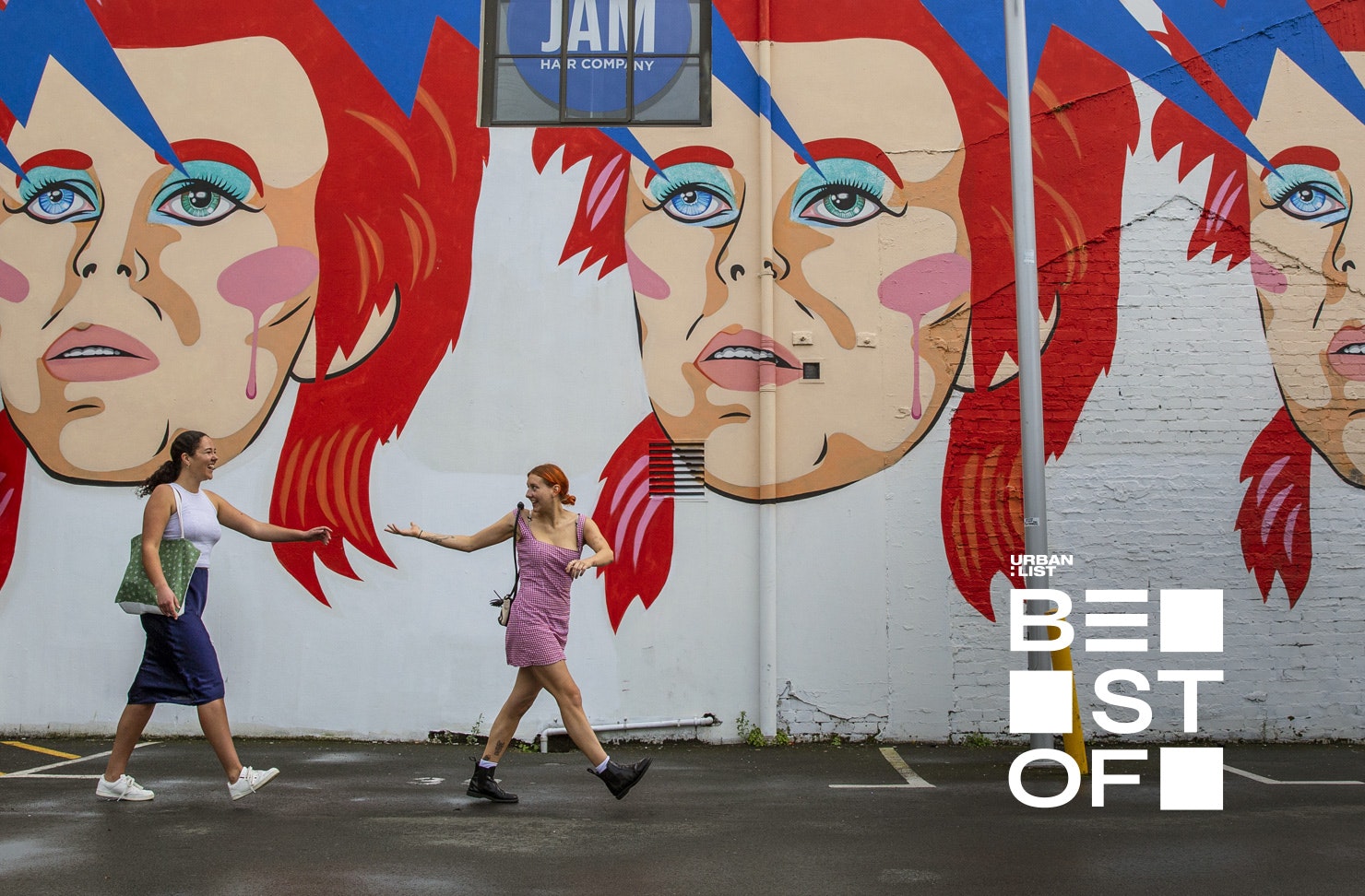 Two people walk by the Bowie mural on Ghuznee Street, Wellington.
