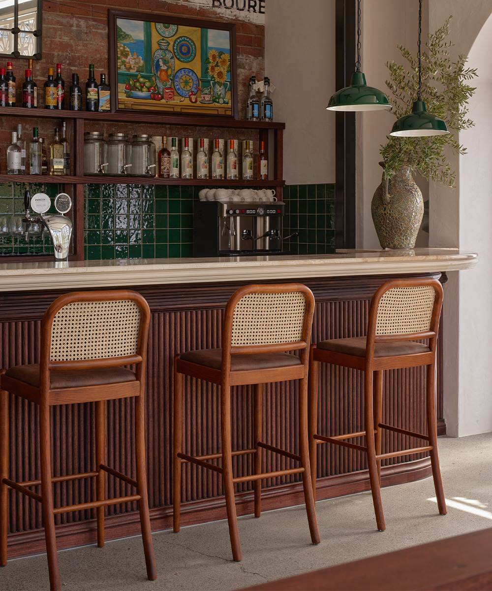 a bar with wicker bar chairs in front it at west end bar Pilloni