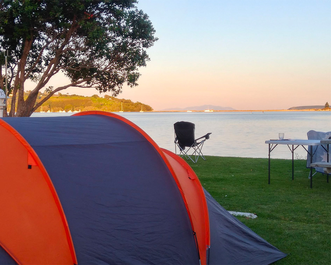 A tent looks out onto the water at Whangateau Holiday Park.