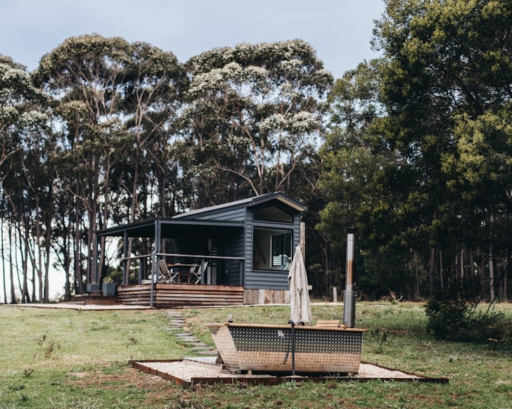 A view of the hut with an outdoor bath outside at Wildernest one of the best NSW Airbnbs