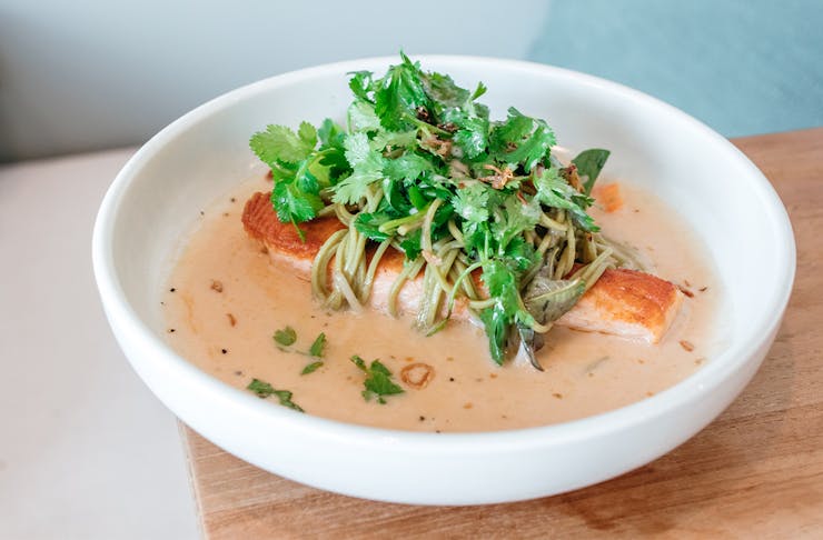 a bowl of salmon laksa with noodles