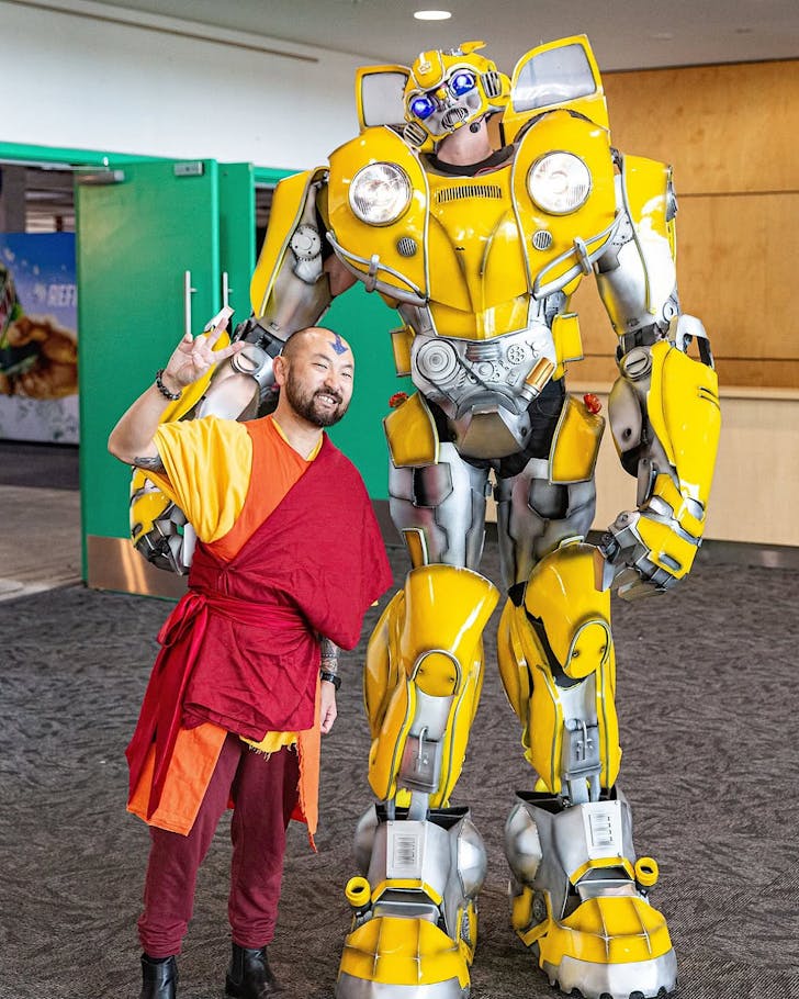 Two cosplayers, one dressed as Ang from Avatar, the other dressed as Bumblebee from Transformers, pose for Armageddon Expo.