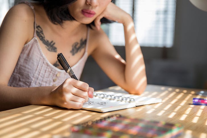 A woman draws on a notepad.