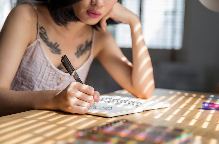A woman draws on a notepad.