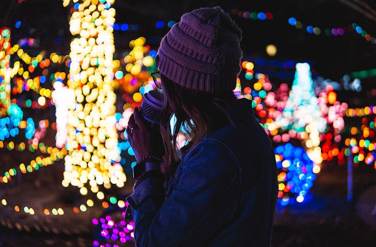 A girl looks at Christmas lights.