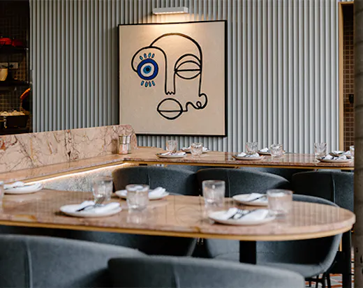 a high marble table with an abstract painting of a face in the background