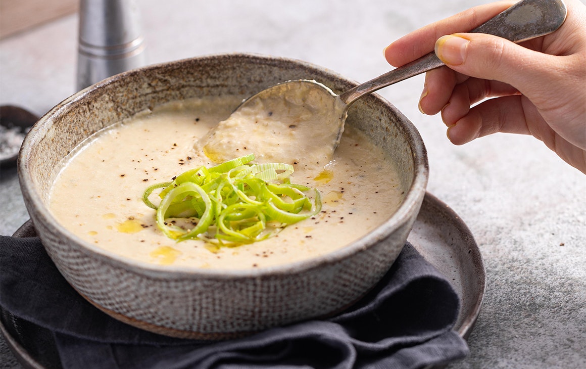 creamy soup topped with sliced spring onion