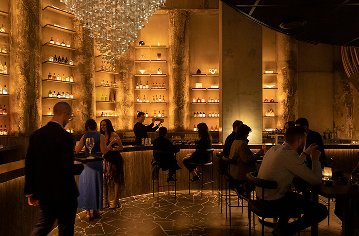A beautifully lit dining room with a warm, golden hue and a grand chandelier at a best restaurant in Melbourne, Yugen Dining