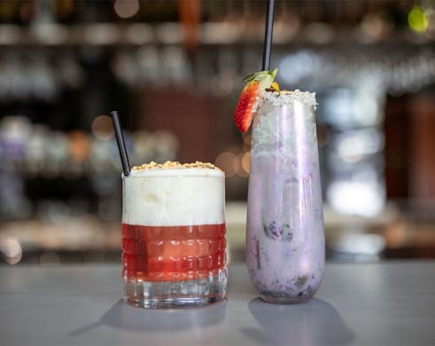 two cocktails on a bar