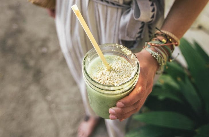 Someone holds a cleansing smoothie.