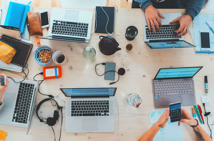 A top down shot of laptops and computers on a desk. 