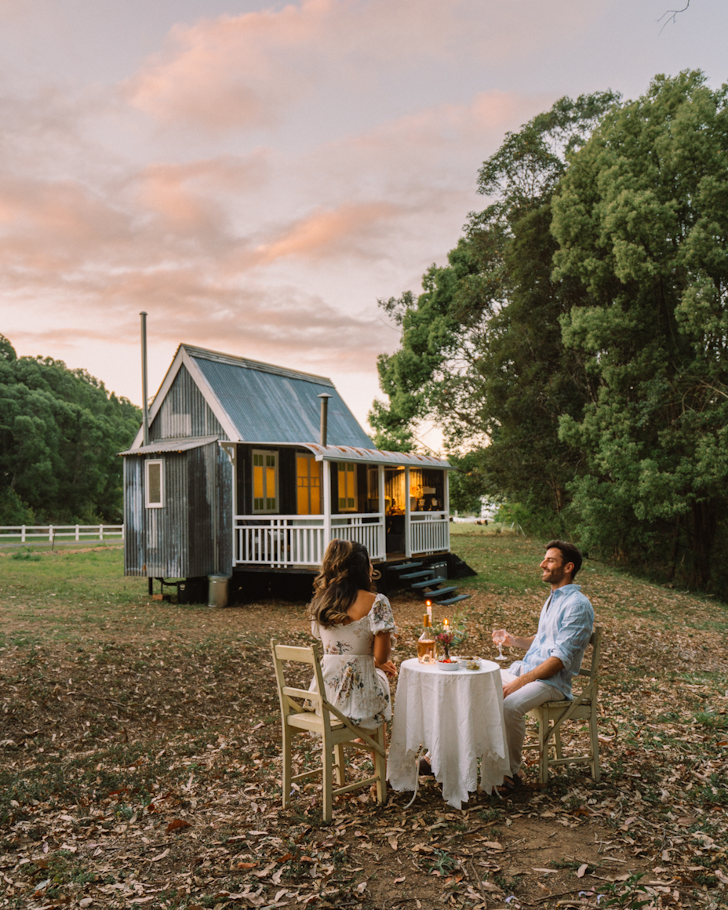 Two people dine outside ​​Palmer & Gunn best cabins cottage Gold Coast