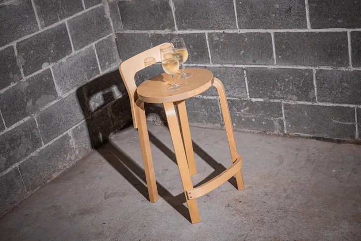two wine glasses on a wooder stool