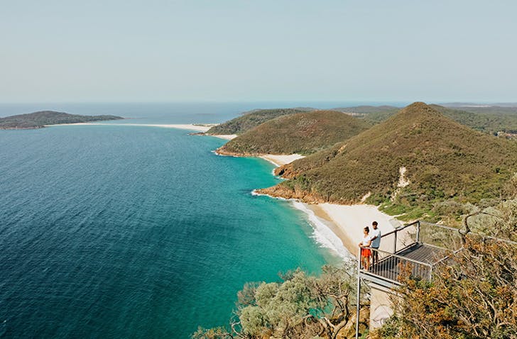 two people standing on lookout overlokoing coastline