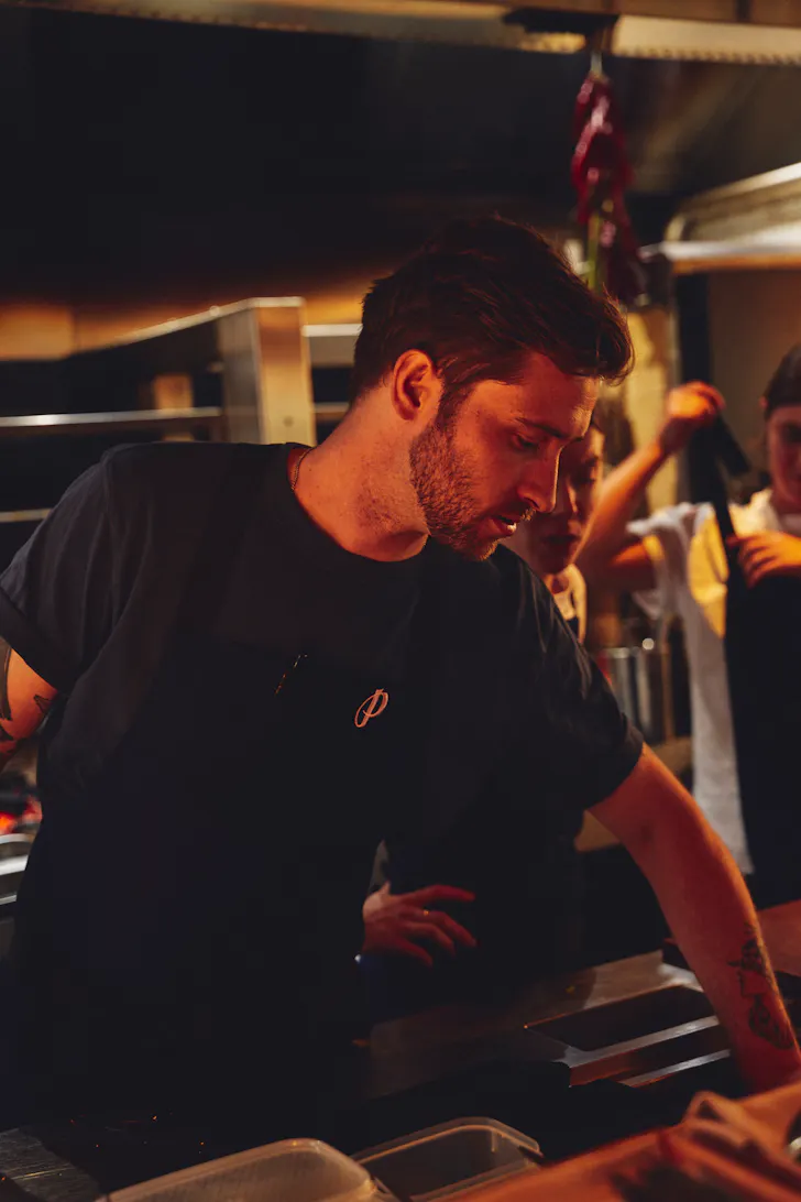 a person wearing an apron in situ in a restaurant kitchen