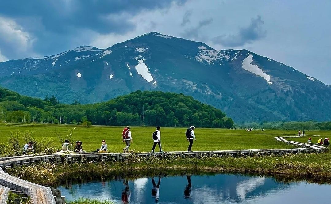 People walking in Japan with a mountain behind them.