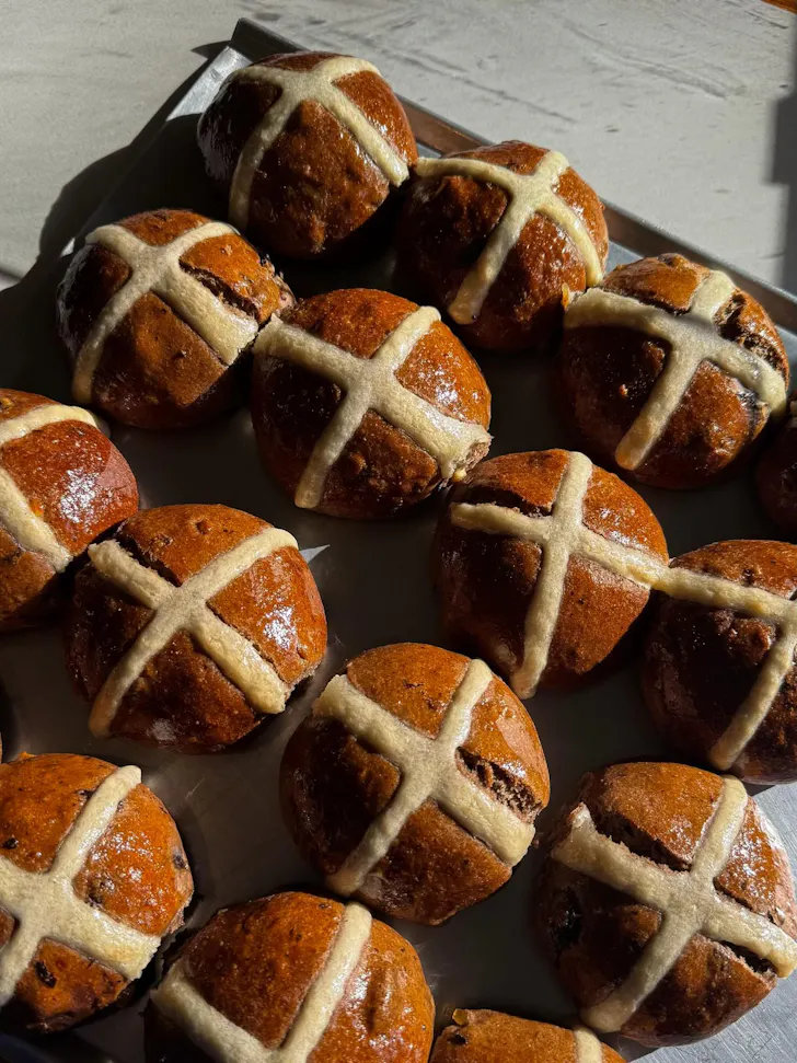 a tray of freshly baked hot cross buns