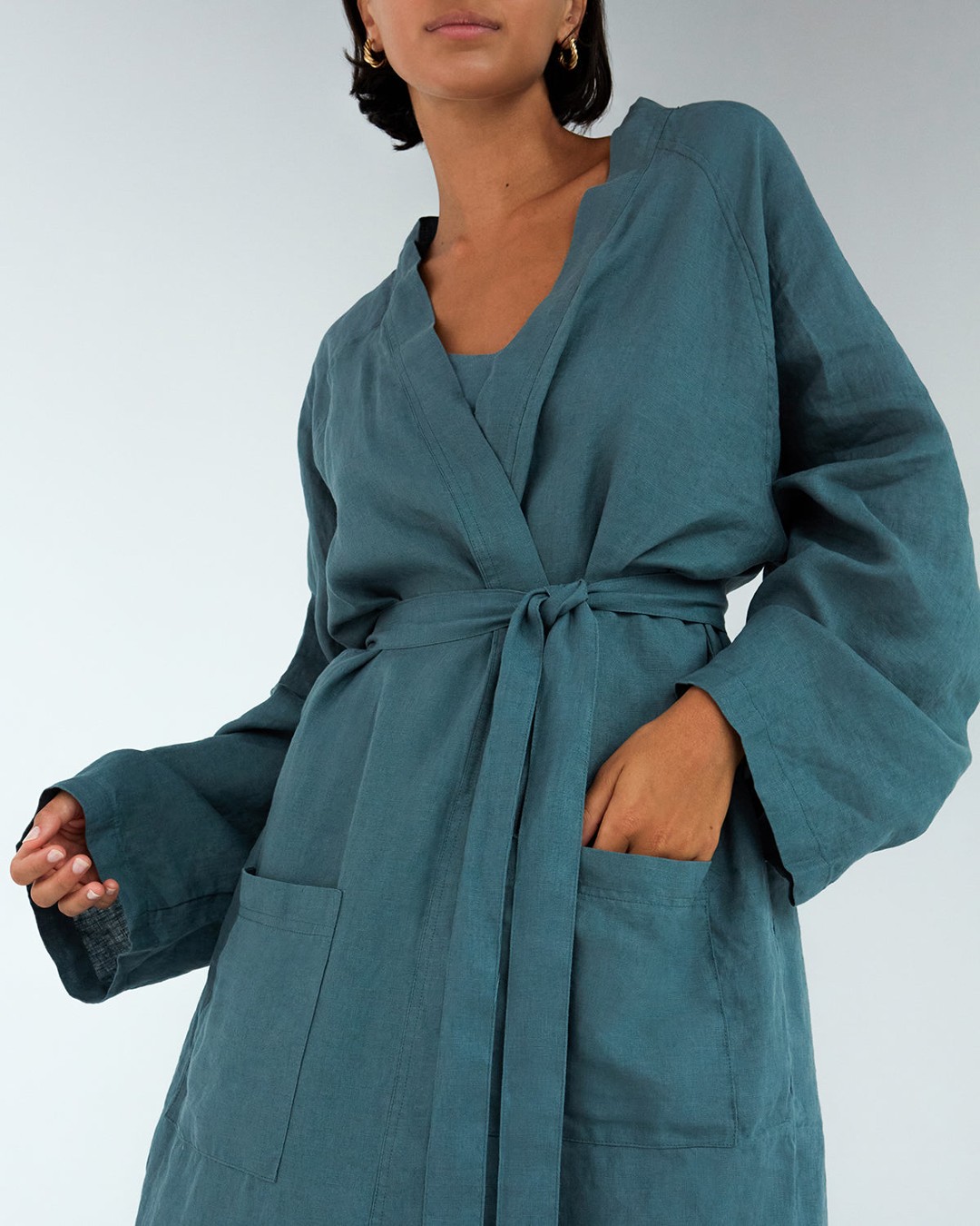 A person wearing a teal coloured linen robe