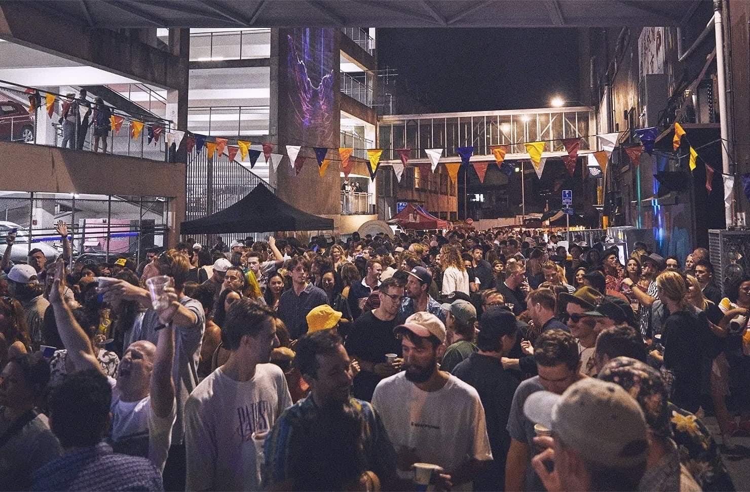 A crowd of music-lovers gather in a laneway to watch a concert at Cross St. Music Festival.