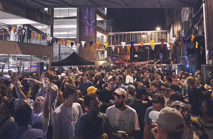 A crowd of music-lovers gather in a laneway to watch a concert at Cross St. Music Festival.