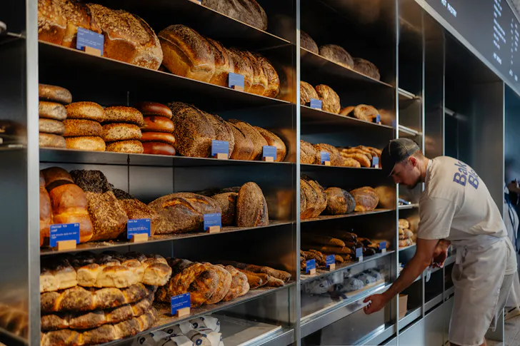 a person handling bread on shelves