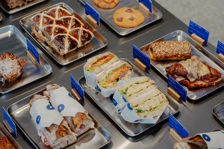 A spread of sandwiches and pastries on silver trays