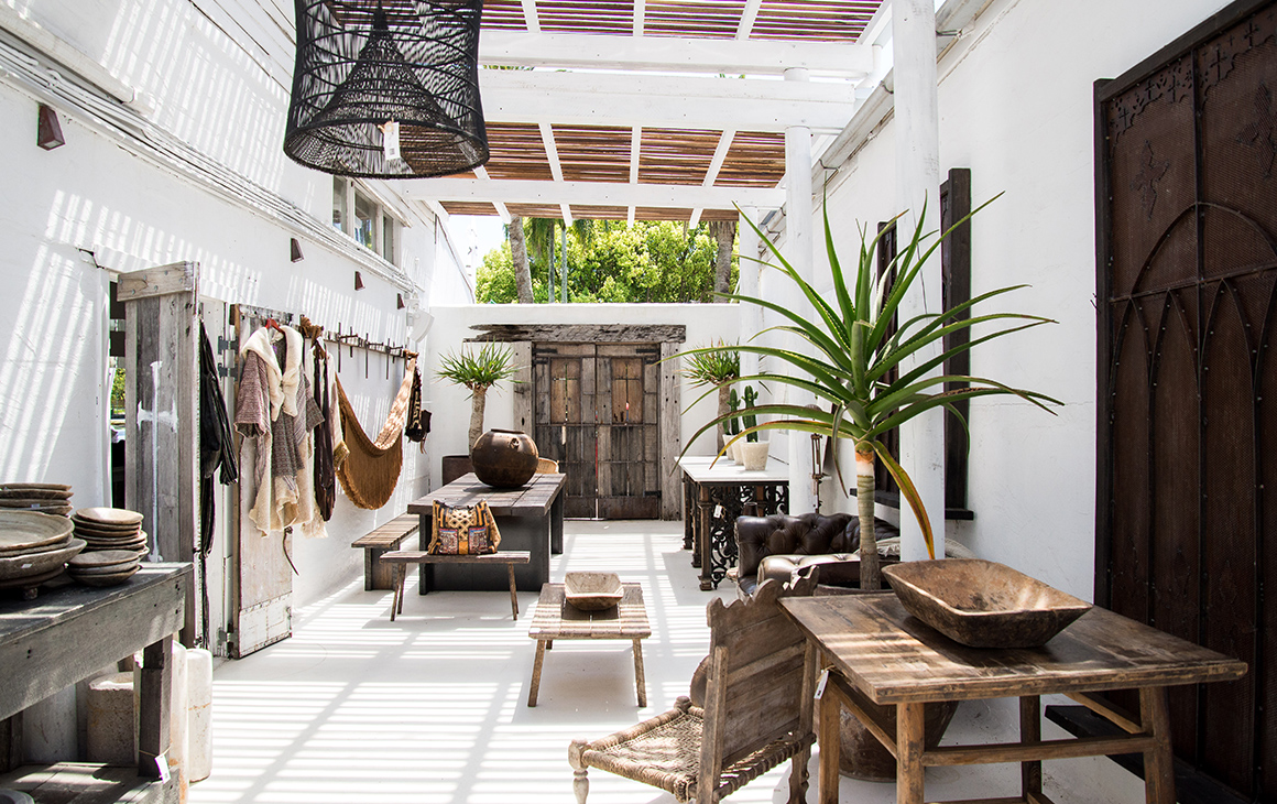 inside a store with white walls and rustic furniture. 