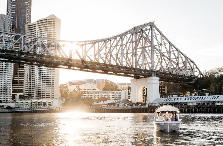 The Brisbane Story Bridge with the sun setting behind it.