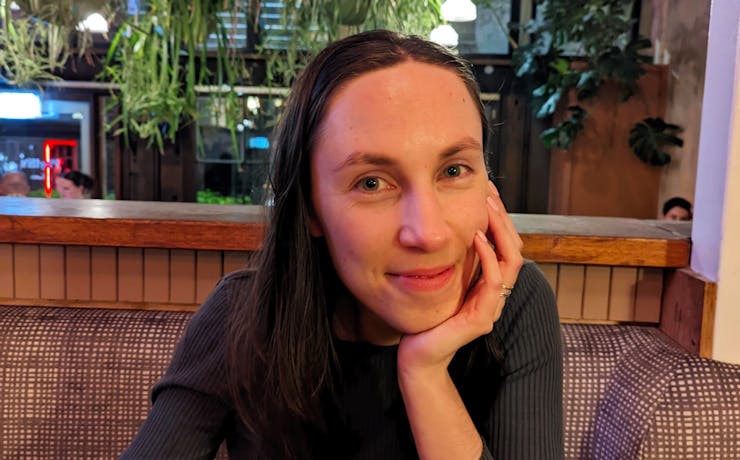 A person sitting at a table with their head in their hand