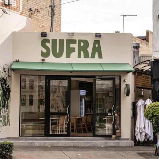 Exterior of Sufra, a modern Lebanese and Afghan restaurant with a green awning and bold signage on a Bexley streetscape.