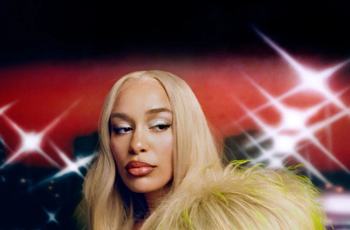 a person with heavy make-up on and glimmering backdrop