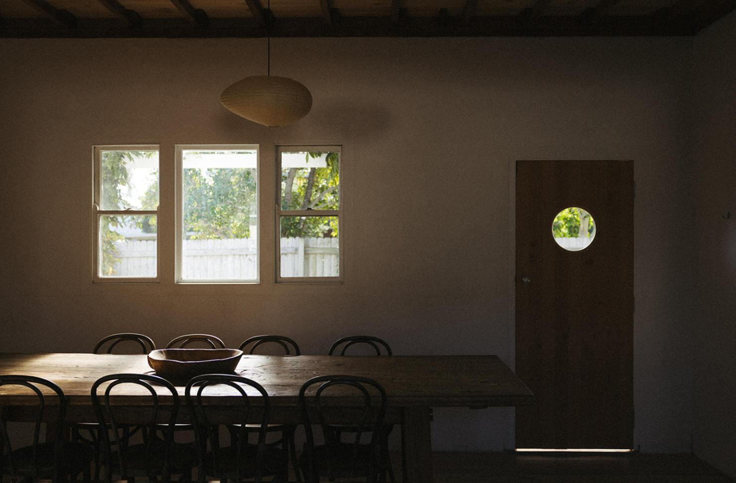 a dark dining room with table and chairs