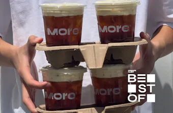 hands holding four montblancs in paper trays